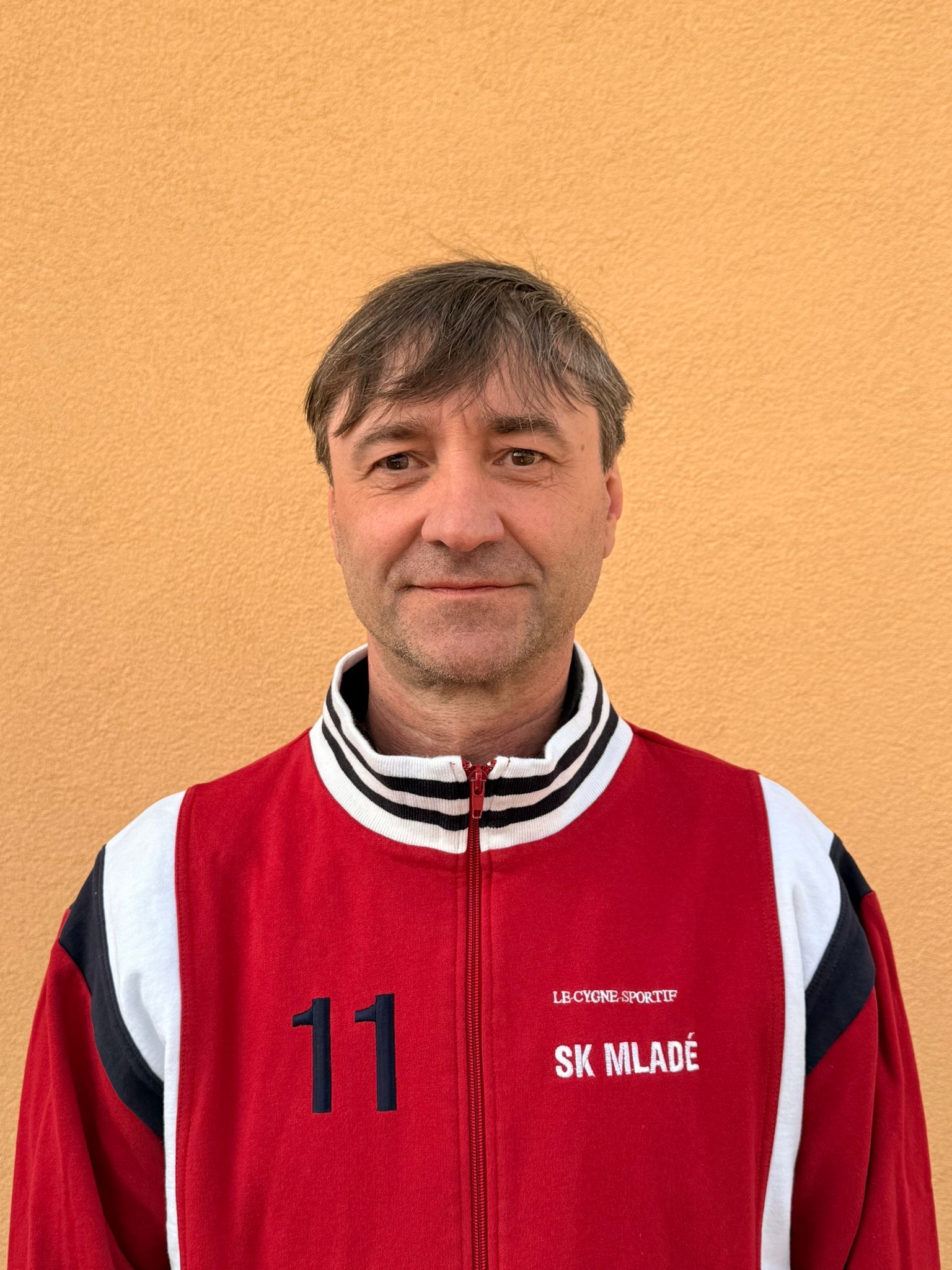 Pavel Smolek v retro červené bundě SK Mladé s číslem 11