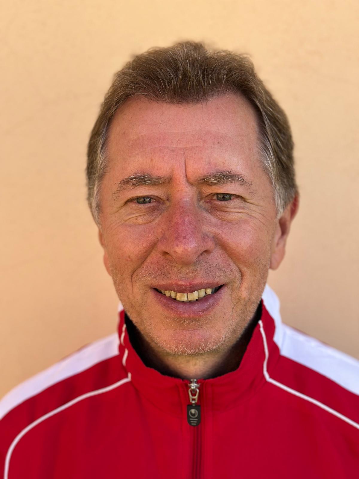 Portrét Petra Lískovce v červené sportovní bundě